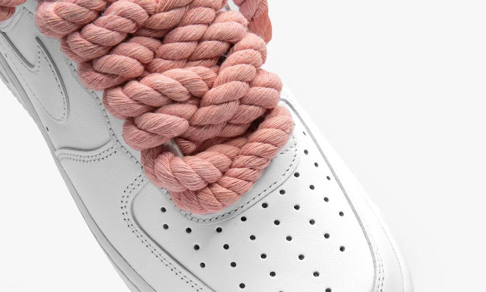 Fehér Nike Air Force 1 cipő rózsaszín, vastag kötélfűzővel.