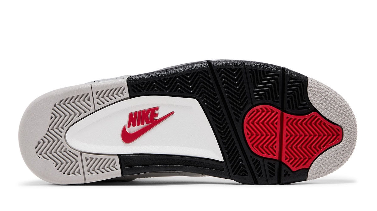 Az Air Jordan 4 Retro "White Cement" cipő talpa fehér, fekete és piros mintázattal, Nike logóval.
