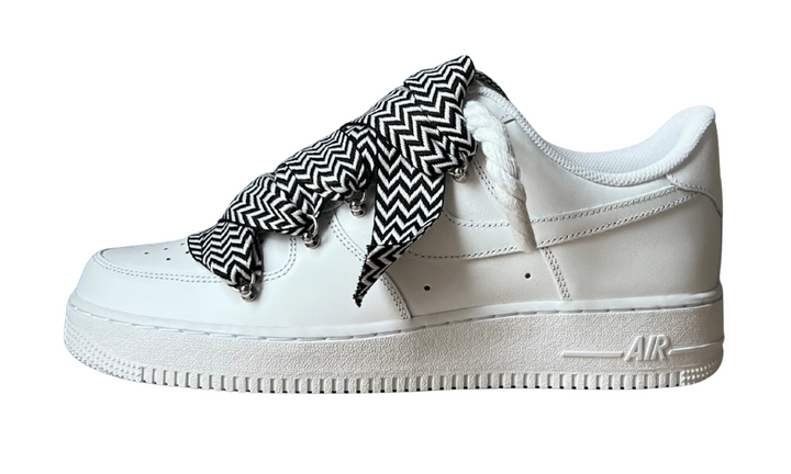 White Nike Air Force 1 sneakers with black and white zigzag rope laces.