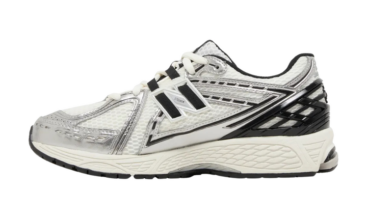 New Balance 1906R ezüst és fekete futócipő fehér hálós felsőrésszel.