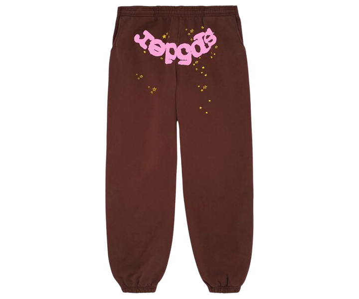 Barna Sp5der Classic Sweatpant rózsaszín logóval és sárga csillagokkal.