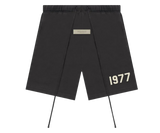 Fekete Fear of God Essentials 1977 rövidnadrág fehér felirattal.