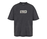 Oversized washed black t-shirt with a patch that reads "I am a piece of paper and I control your entire life".