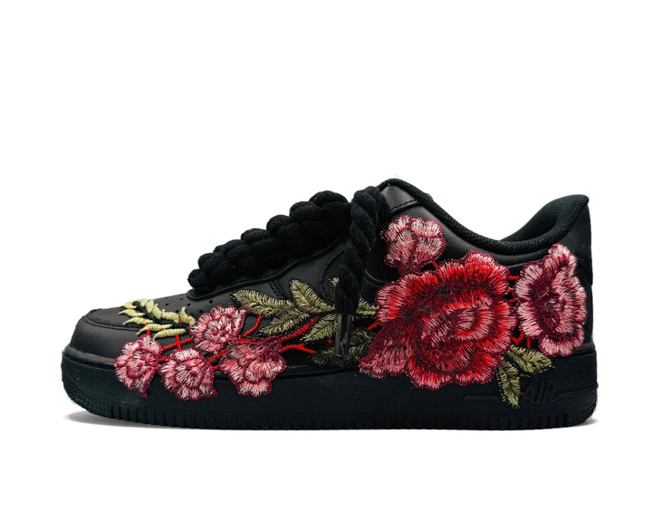 Fekete Nike Air Force 1 Low cipő piros és rózsaszín virágmintával és kötélfűzővel.