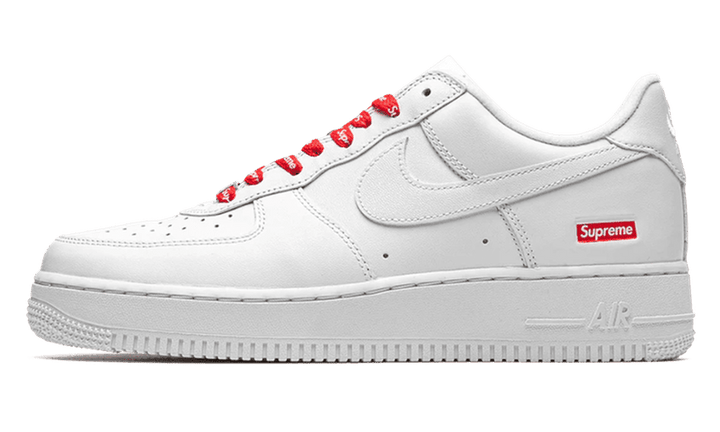Fehér Nike Air Force 1 Low Supreme cipő piros Supreme feliratos fűzővel.