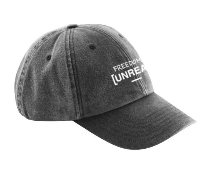 Unreal Industries washed grey baseball cap with "FREEDOM [UNREA" text.