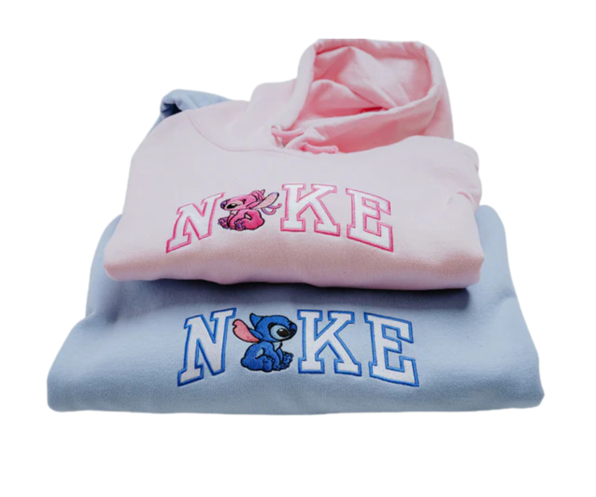 Két hímzett pulóver, egy rózsaszín angyalkával és egy kék szörnyeteggel.