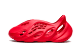 Piros Yeezy Foam Runner sziluett zöld háttérrel.