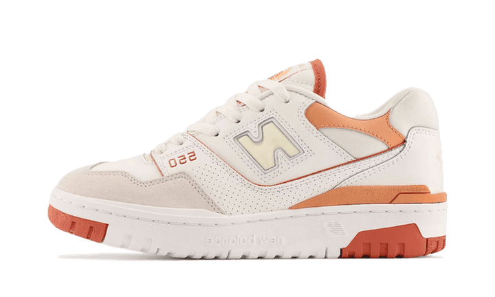 New Balance 550 Au Lait cipő krémszínű alappal és narancssárga részletekkel.